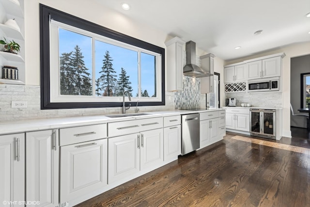 kitchen featuring white cabinetry, wall chimney exhaust hood, beverage cooler, and sink