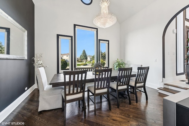 dining space featuring an inviting chandelier, high vaulted ceiling, and dark hardwood / wood-style floors