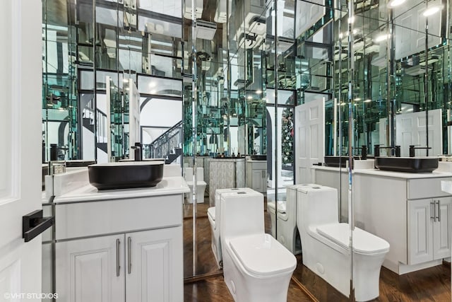 bathroom with hardwood / wood-style flooring, vanity, and toilet