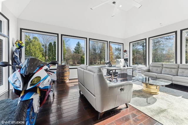 living room featuring dark wood-type flooring, ceiling fan, vaulted ceiling, and a wealth of natural light