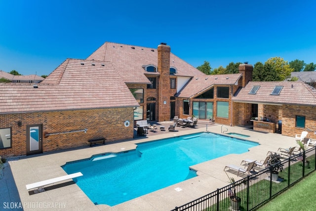 view of swimming pool with a patio area and a diving board