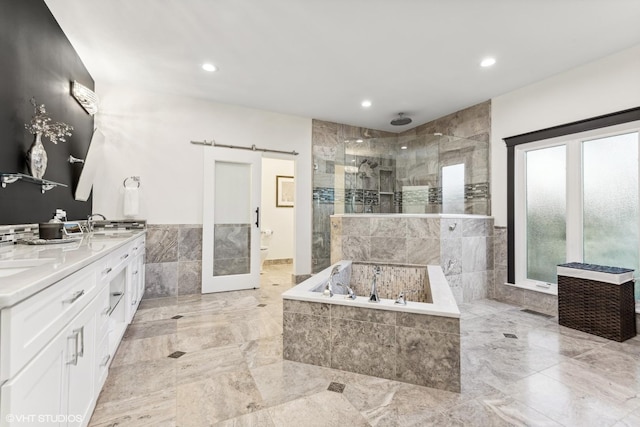 full bathroom with tile walls, vanity, shower with separate bathtub, and toilet