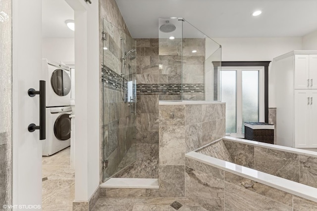 bathroom with stacked washer and clothes dryer and walk in shower