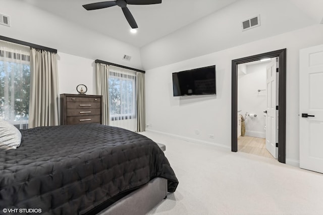 carpeted bedroom featuring ceiling fan, lofted ceiling, and ensuite bathroom