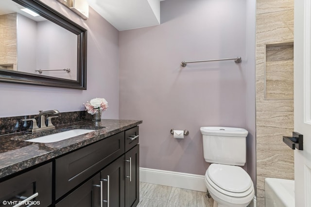 bathroom featuring vanity, a bath, and toilet