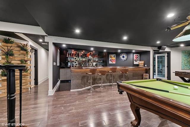 recreation room with bar and hardwood / wood-style floors