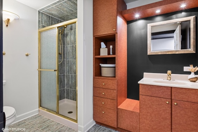 bathroom with vanity, a shower with shower door, and toilet