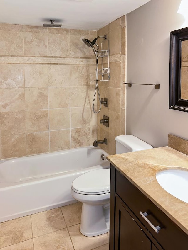 full bathroom featuring vanity, tile patterned flooring, tiled shower / bath combo, and toilet