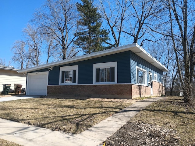 view of front facade with brick siding, a front lawn, concrete driveway, and a garage