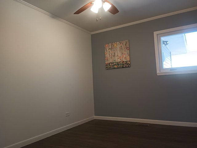 spare room with dark wood-type flooring, a ceiling fan, baseboards, and ornamental molding