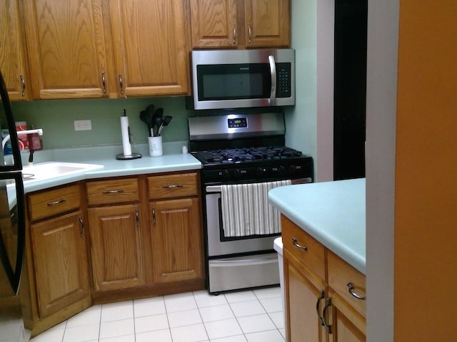 kitchen with light tile patterned flooring and appliances with stainless steel finishes