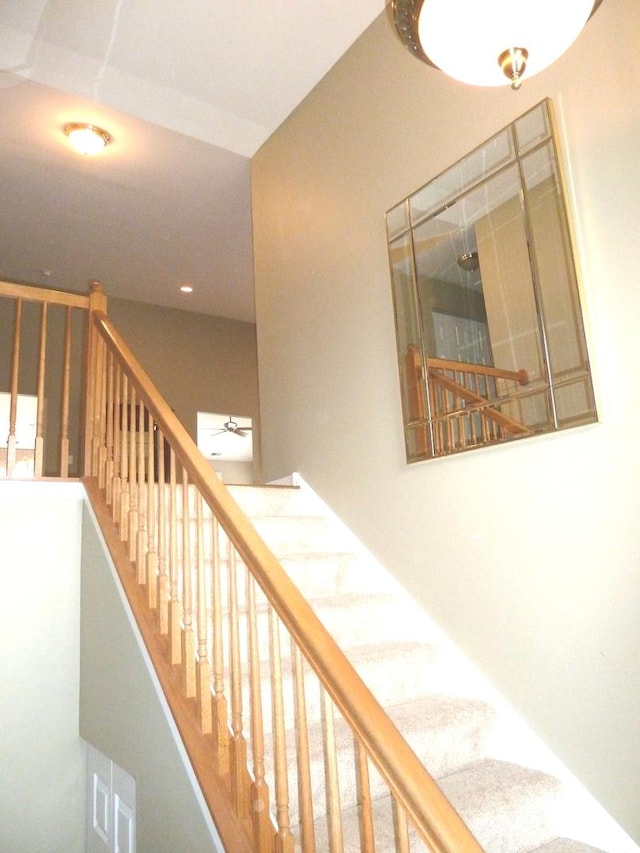 stairway featuring ceiling fan