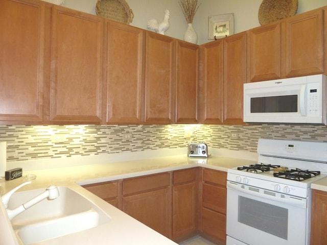 kitchen featuring sink, white appliances, and decorative backsplash