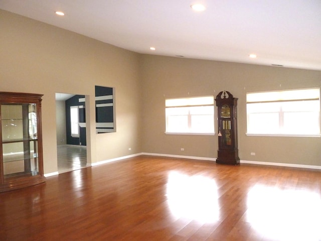 unfurnished living room featuring hardwood / wood-style flooring and vaulted ceiling