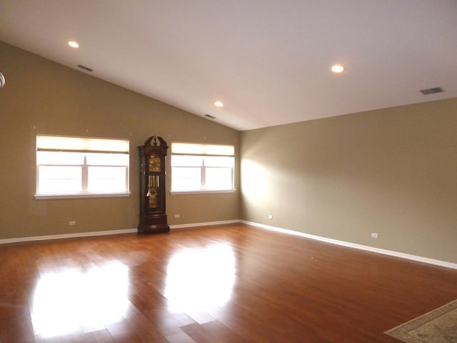 spare room with lofted ceiling and light wood-type flooring