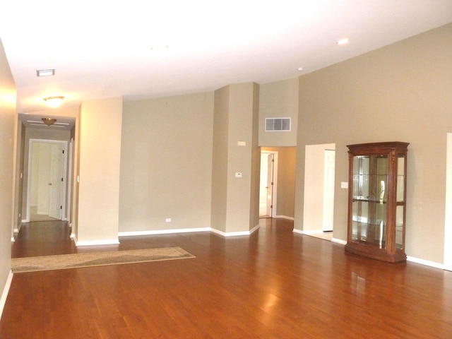 unfurnished room with dark hardwood / wood-style flooring and high vaulted ceiling