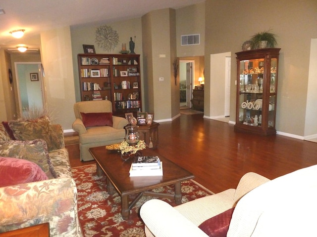 living room featuring vaulted ceiling and dark hardwood / wood-style flooring