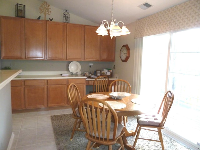 tiled dining room with an inviting chandelier and vaulted ceiling