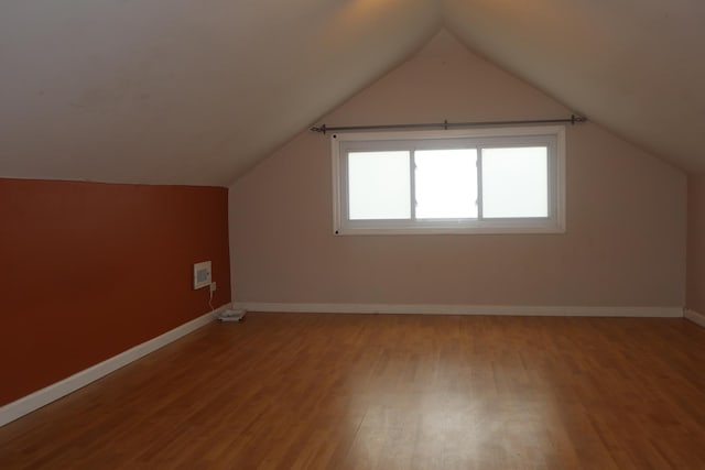 bonus room with baseboards, light wood-type flooring, and lofted ceiling
