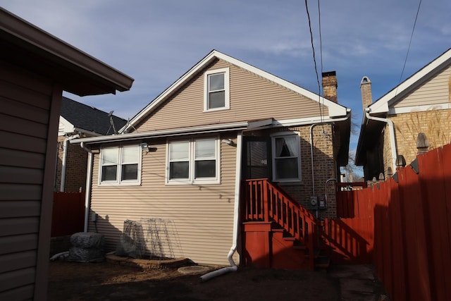 rear view of property featuring fence