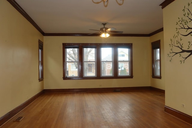 unfurnished room with crown molding, wood-type flooring, and baseboards