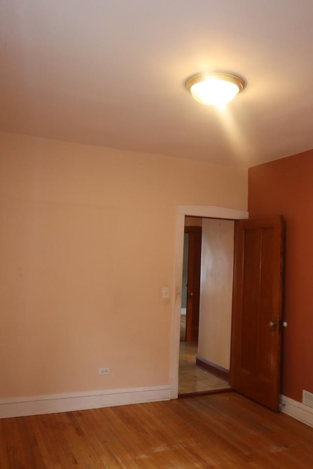spare room featuring light wood-style floors and baseboards