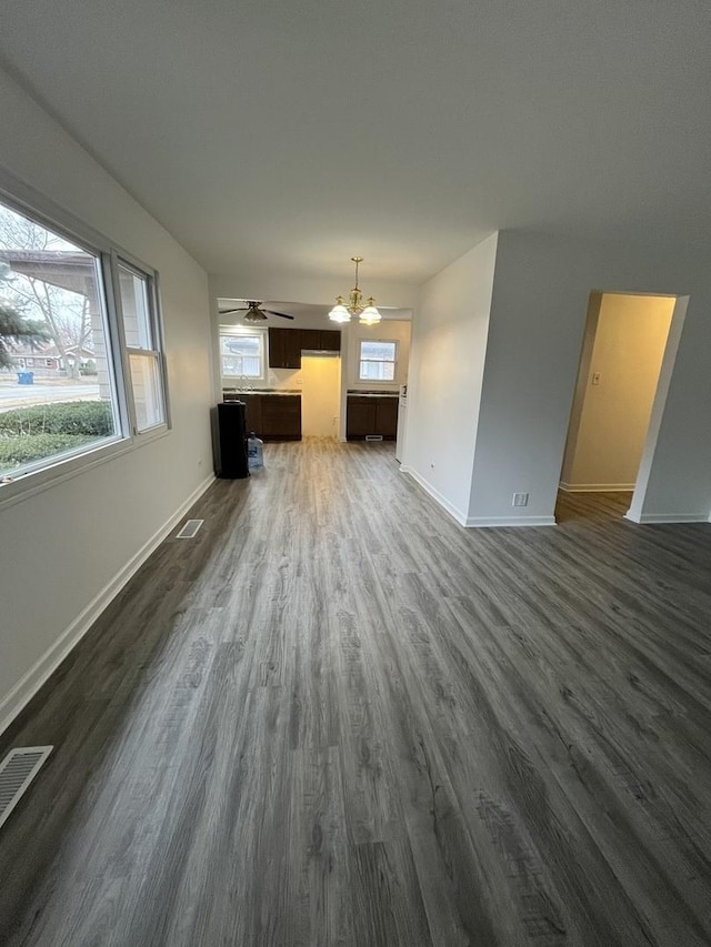 unfurnished living room with dark hardwood / wood-style flooring and a notable chandelier