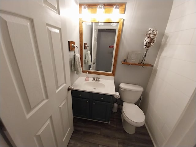 bathroom with hardwood / wood-style flooring, vanity, and toilet