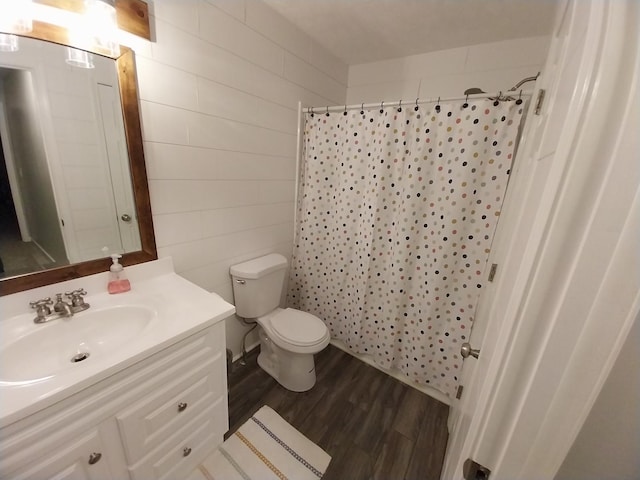 bathroom with a shower with curtain, wood-type flooring, toilet, and vanity