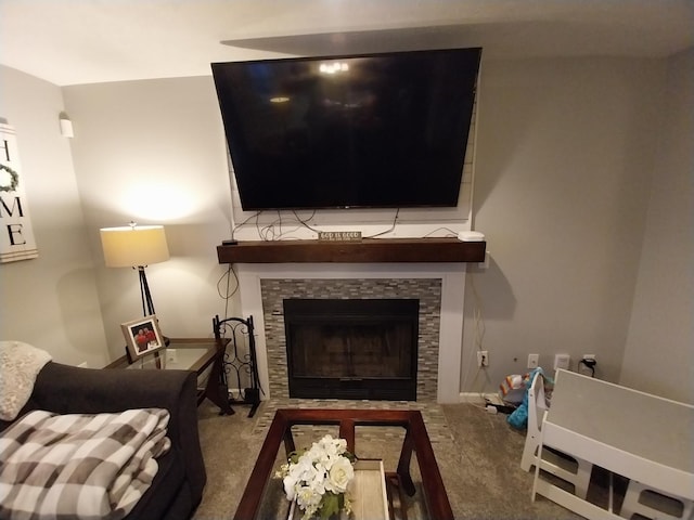 sitting room featuring a stone fireplace and carpet floors