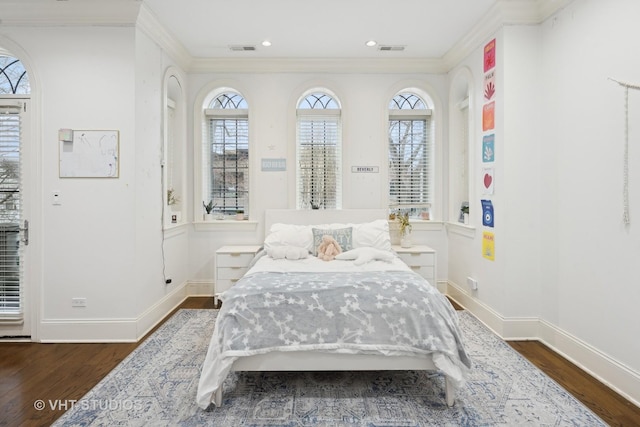 bedroom with multiple windows, crown molding, and dark hardwood / wood-style floors