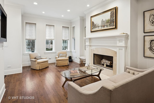 living room with ornamental molding, a high end fireplace, and wood-type flooring