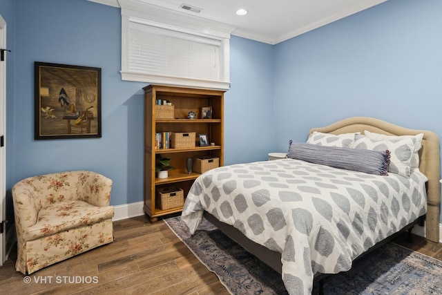 bedroom with dark hardwood / wood-style flooring and crown molding