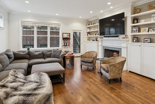 living room featuring crown molding, wood-type flooring, and built in shelves