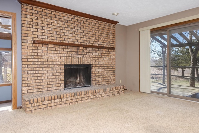 unfurnished living room featuring a brick fireplace, carpet, and a textured ceiling