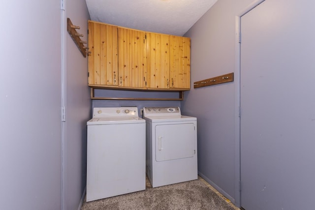 laundry room featuring washing machine and clothes dryer, cabinet space, and carpet