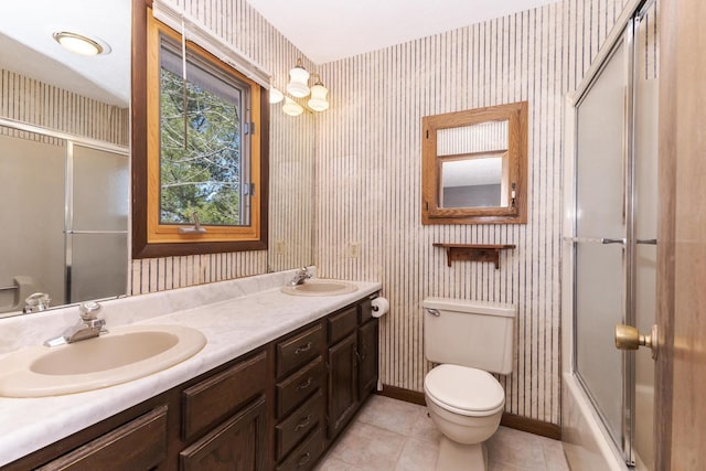 full bathroom featuring wallpapered walls, a sink, toilet, and double vanity
