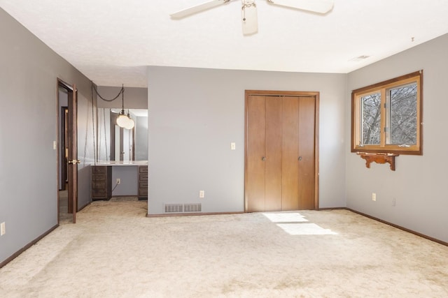 unfurnished bedroom featuring a closet, carpet flooring, visible vents, and baseboards
