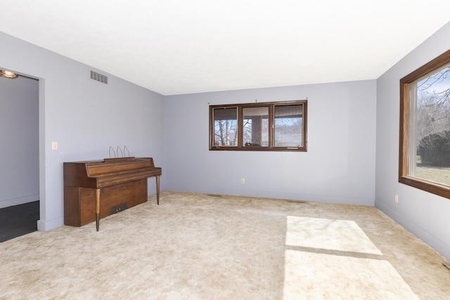 spare room featuring carpet flooring and visible vents