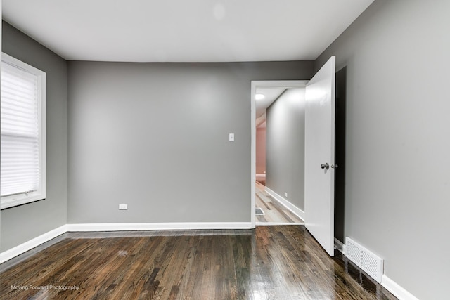 spare room with dark hardwood / wood-style floors