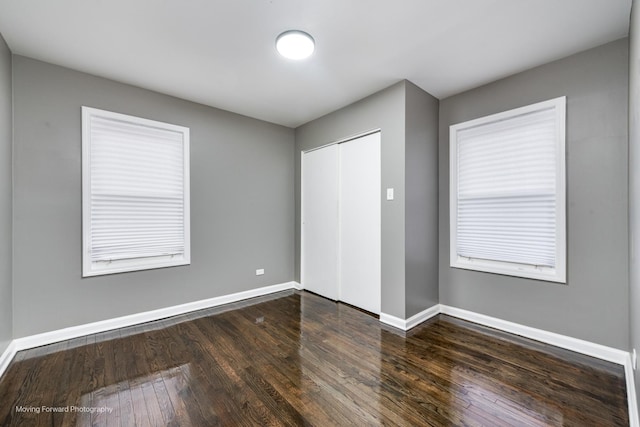 unfurnished bedroom featuring dark hardwood / wood-style floors and a closet