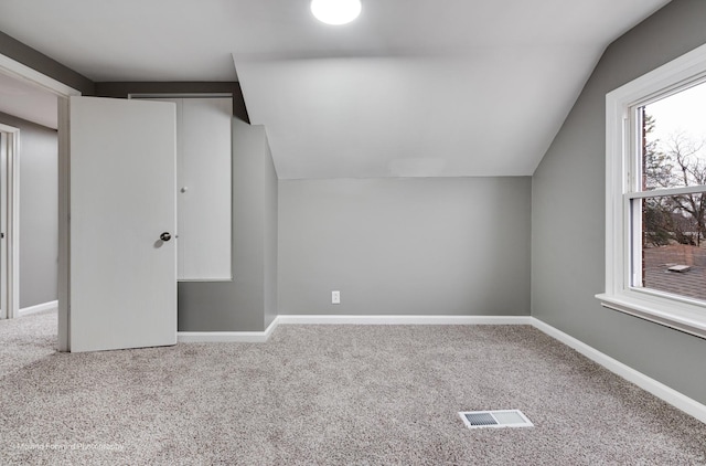 bonus room featuring vaulted ceiling and carpet floors