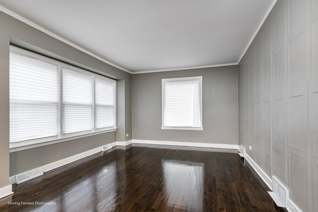 empty room with hardwood / wood-style flooring and crown molding