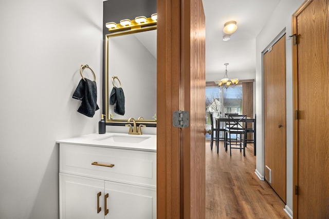 bathroom featuring vanity, hardwood / wood-style flooring, and a chandelier