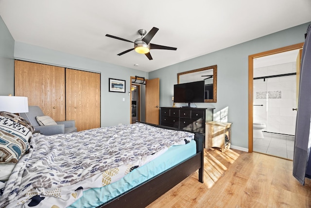 bedroom featuring ensuite bath, light hardwood / wood-style flooring, ceiling fan, and a closet