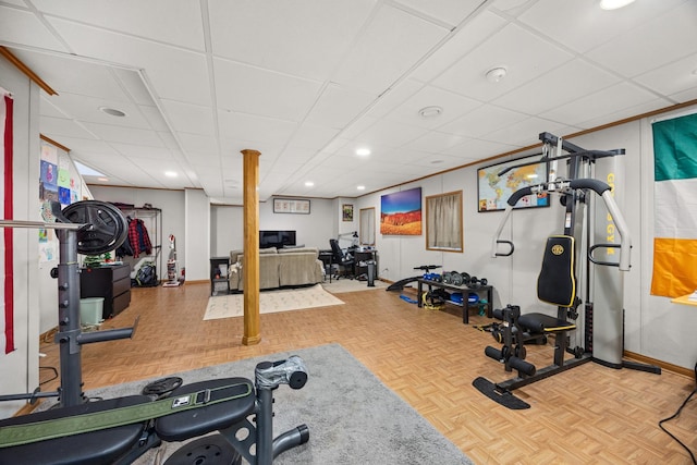 exercise room with a drop ceiling and light parquet flooring