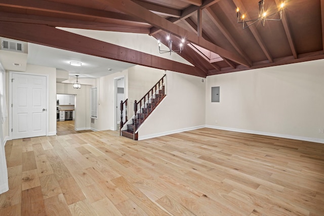 basement with an inviting chandelier, electric panel, and light hardwood / wood-style floors