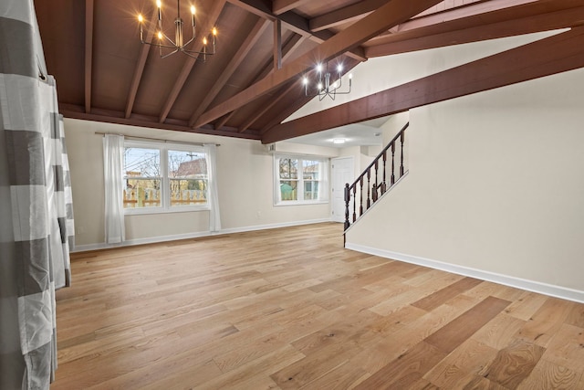 unfurnished living room with a notable chandelier, light hardwood / wood-style flooring, and vaulted ceiling with beams