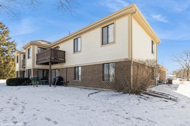 snow covered house with cooling unit and a balcony