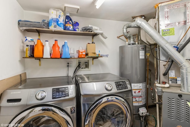 clothes washing area featuring water heater and washer and clothes dryer